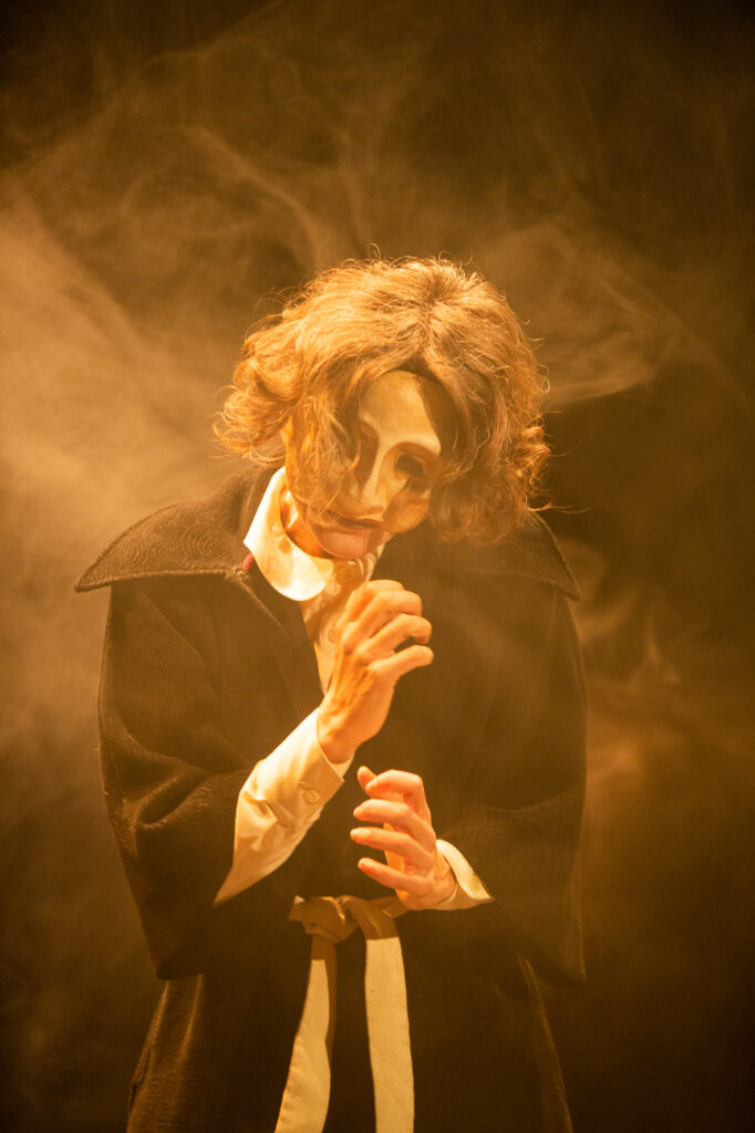 Cecilia Scrittore con una maschera in Terra e Polvere (da sparo)